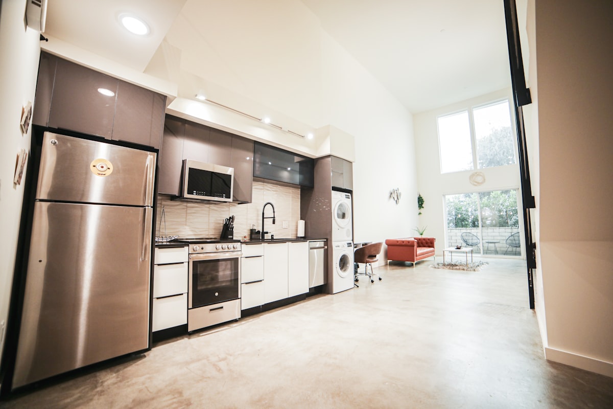 Kitchen with fridge, stove, and stacked washer/dryer